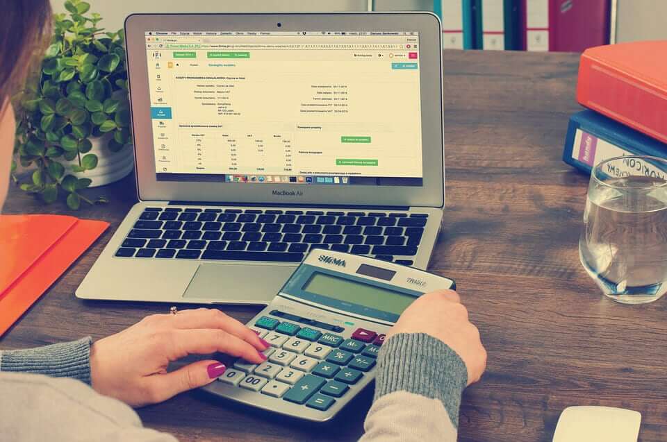 Woman checking tax numbers with a large calculator
