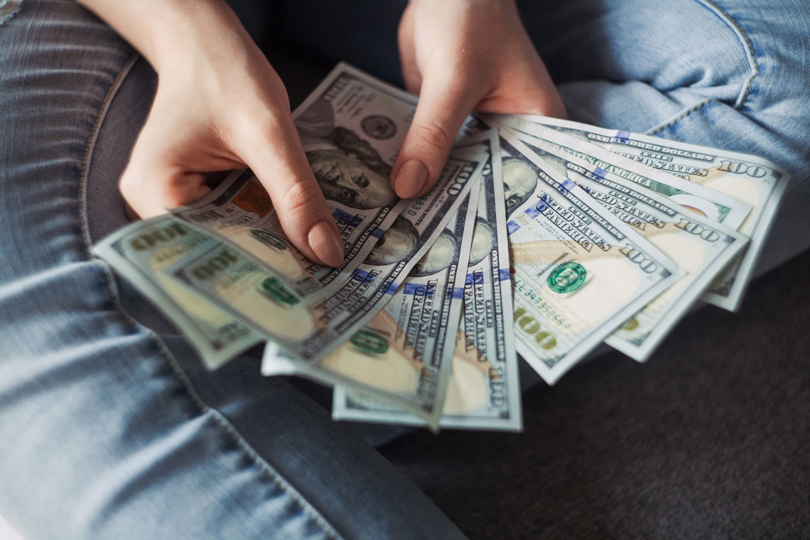 Person holding wages in form of cash