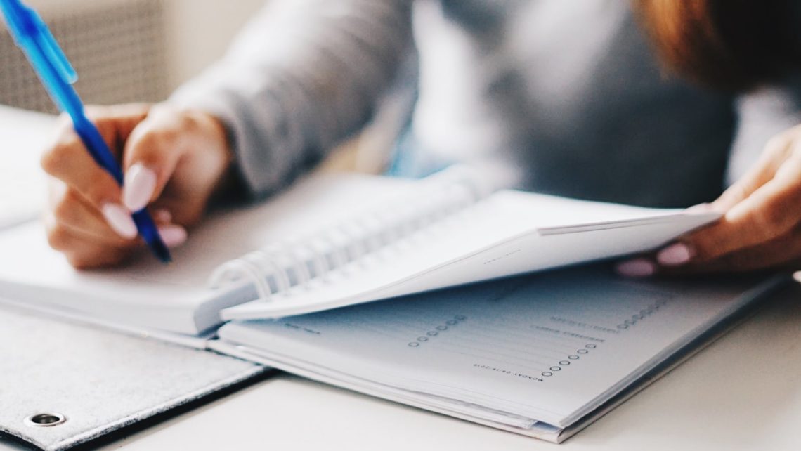 Woman noting important tax filing dates in planner